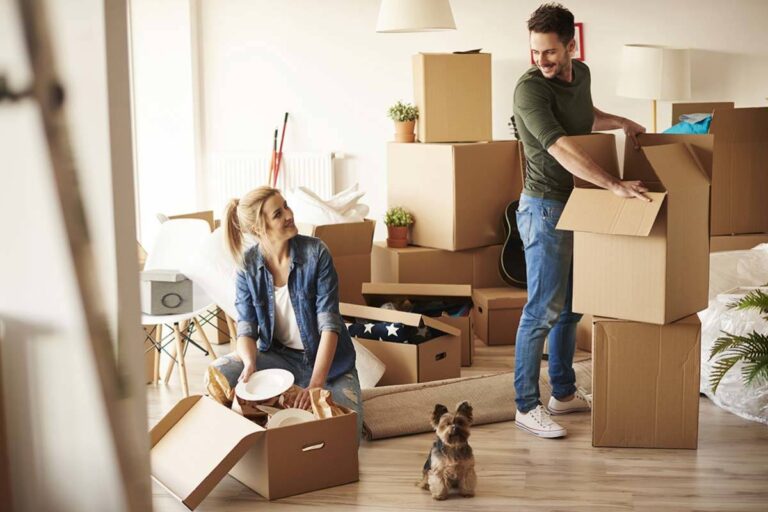 Couple unpacking boxes in room.